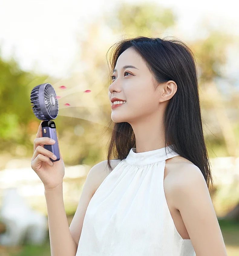 Mujer refrescándose la cara con Veltoso Aura al aire libre
